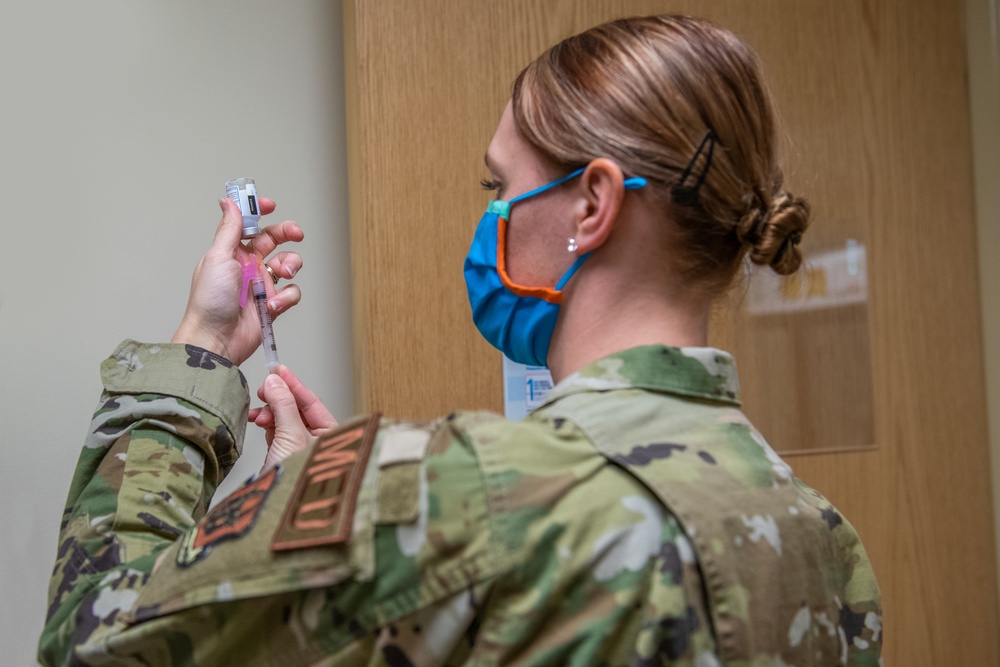 Nevada National Guard medic in camouflage uniform preparing a vaccination syringe at Battle Born Youth Challenge Academy