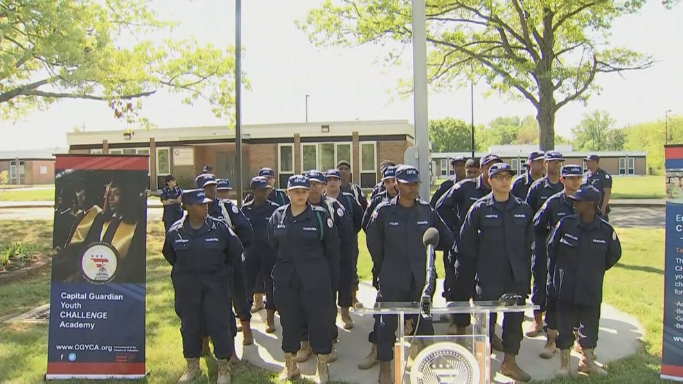 CGYCA cadets in navy uniforms and caps standing in formation during outdoor ceremony at Camp Schwartz