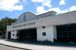 Hollywood Hills High School white stucco entrance building with arched facade and palm trees