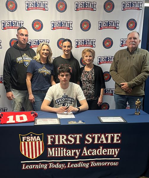 Student-athlete signing with Lycoming College surrounded by family at FSMA branded table