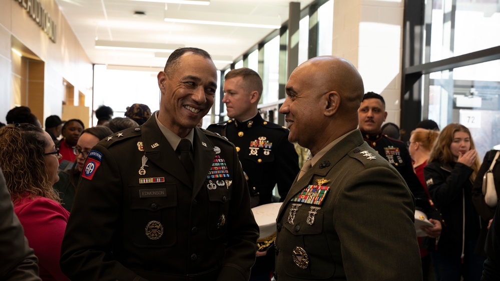 Senior Army and Marine officers with service ribbons mingling with families at academy event