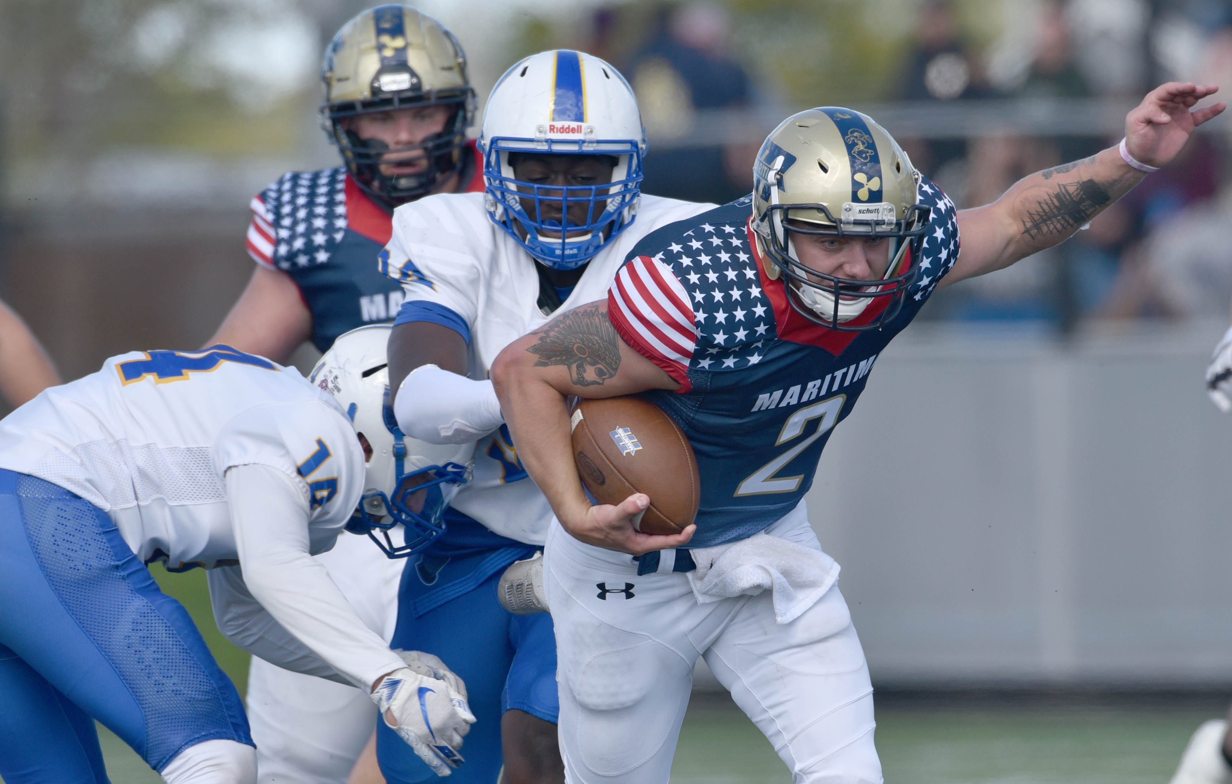 Buccaneers football player in patriotic American flag jersey carrying ball during game action
