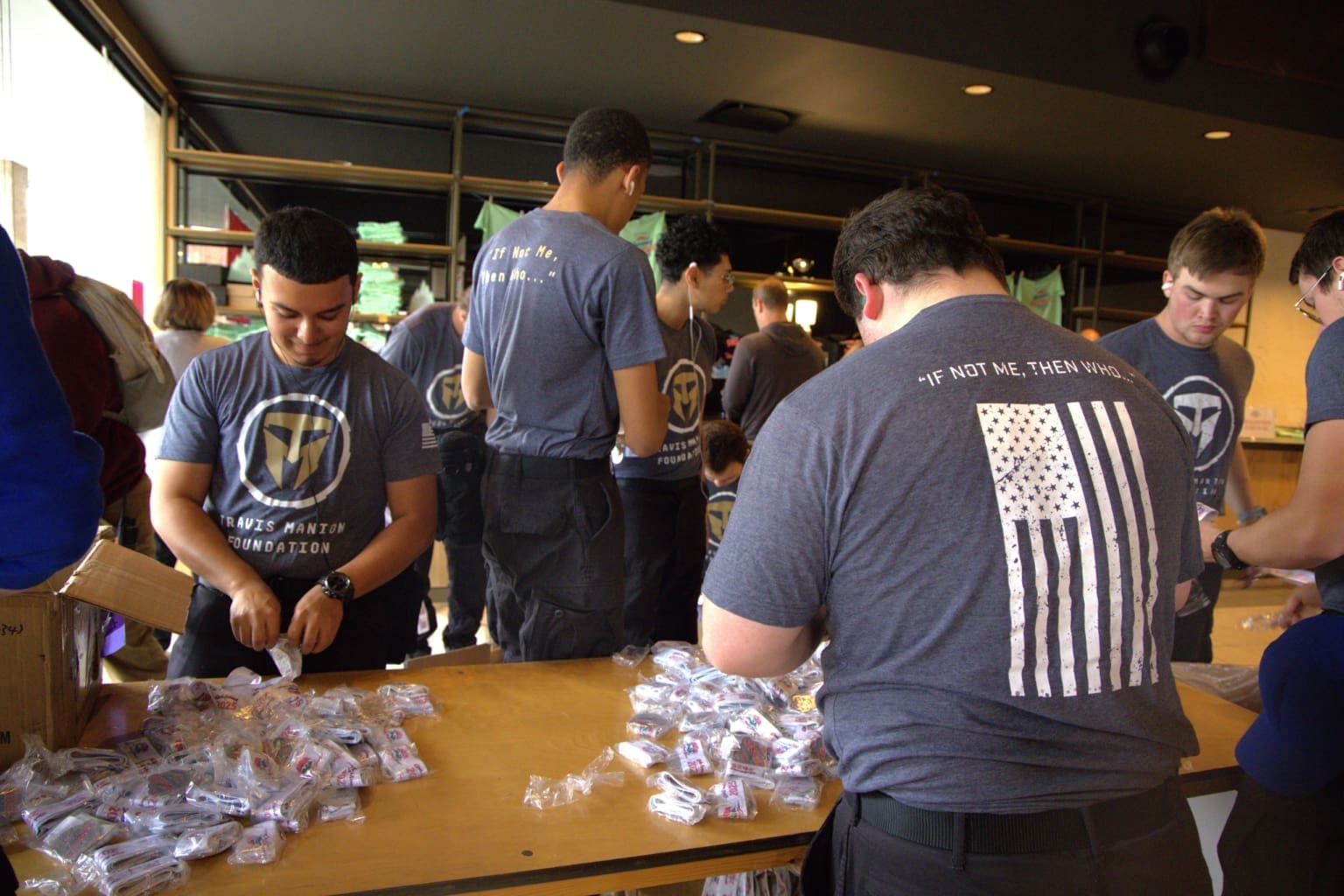 Students in Travis Manion Foundation t-shirts packing care packages at community service event