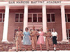 Vintage photo of cadets and students in 1950s attire posing at original brick academy building