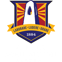 Shield-shaped logo featuring tower silhouette with red and gold rays, motto banner, and founding year 1884
